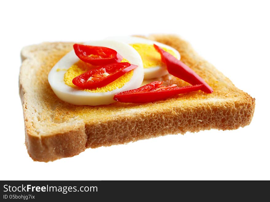 Toasted bread and boiled egg slices with fresh red chili , isolated on white