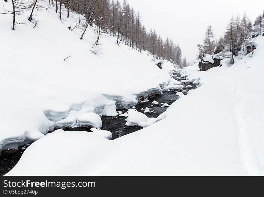 A winter landscape with river and mountain in the background. A winter landscape with river and mountain in the background