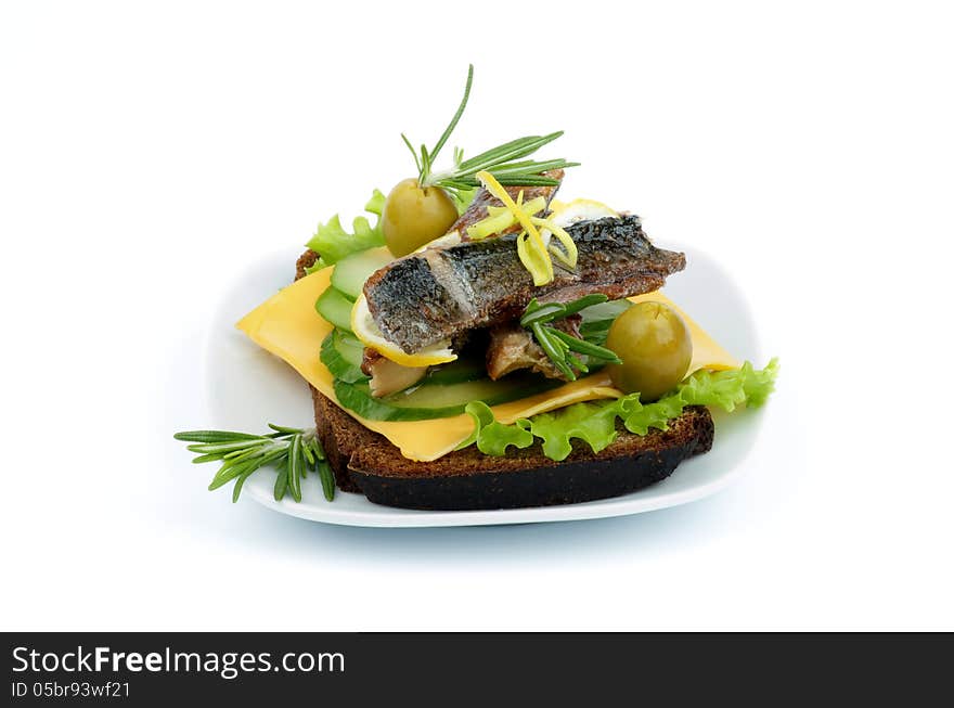 Delicious Snack of Smoked Sardines, Lettuce, Cucumber, Cheese, Olives with Lemon, Rosemary and Whole Wheat Bread on White Plate on white background. Delicious Snack of Smoked Sardines, Lettuce, Cucumber, Cheese, Olives with Lemon, Rosemary and Whole Wheat Bread on White Plate on white background