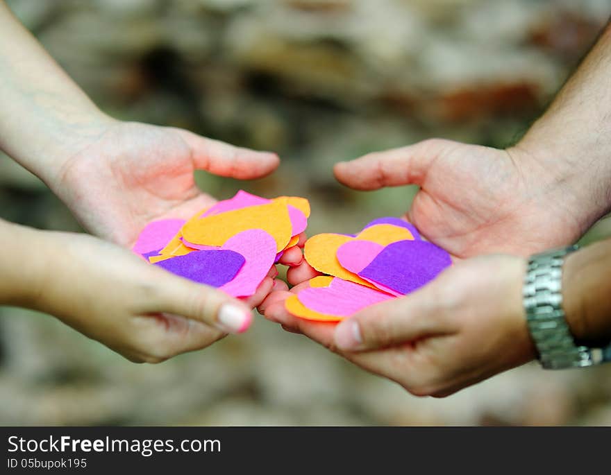 Four hands with beautiful colored paper hearts. Four hands with beautiful colored paper hearts