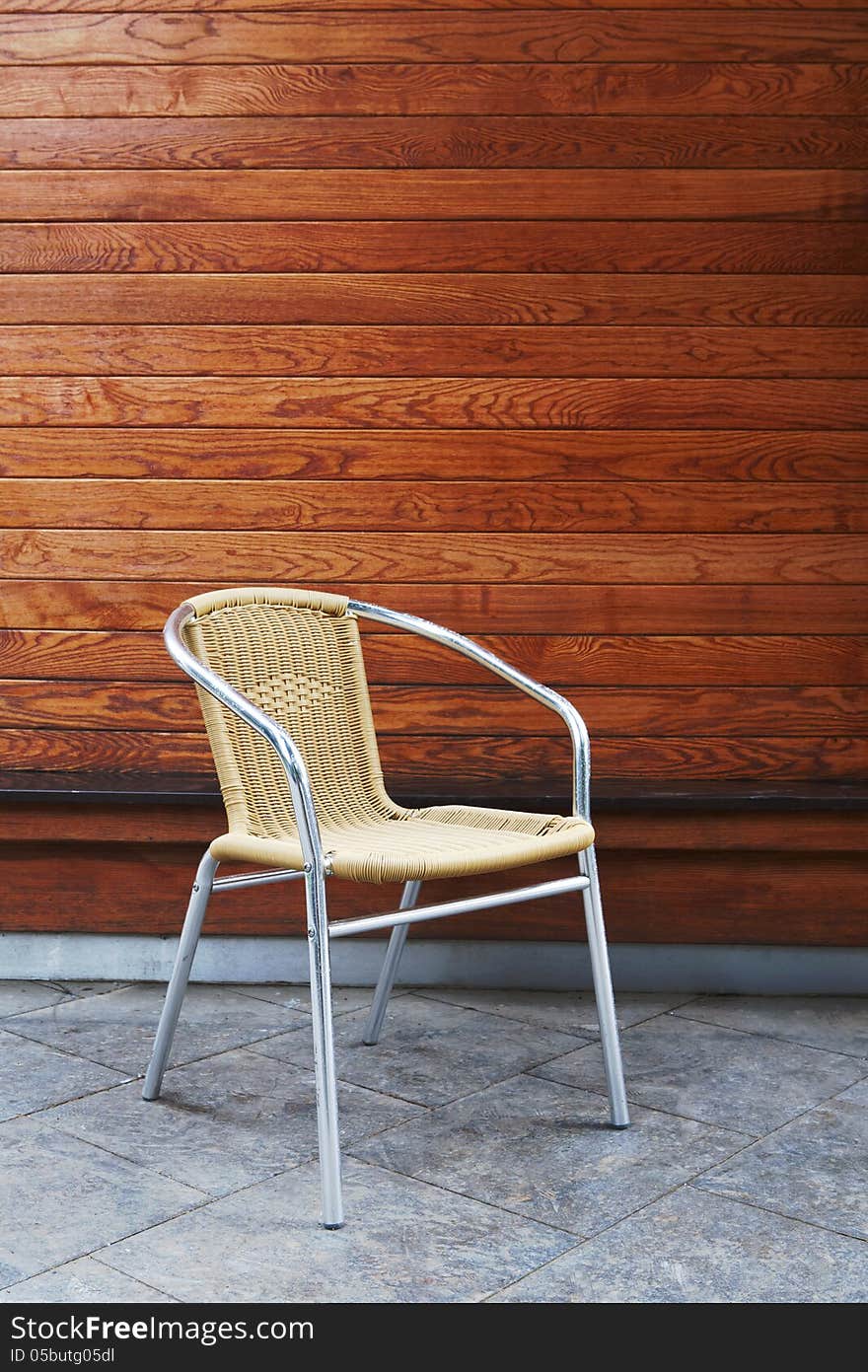 Aluminum chair under panel pine wood background