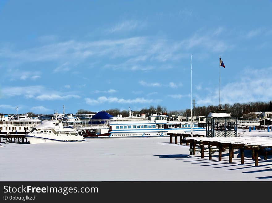 Yachts, boats and river passenger ships in the snow on a winter dock. Yachts, boats and river passenger ships in the snow on a winter dock