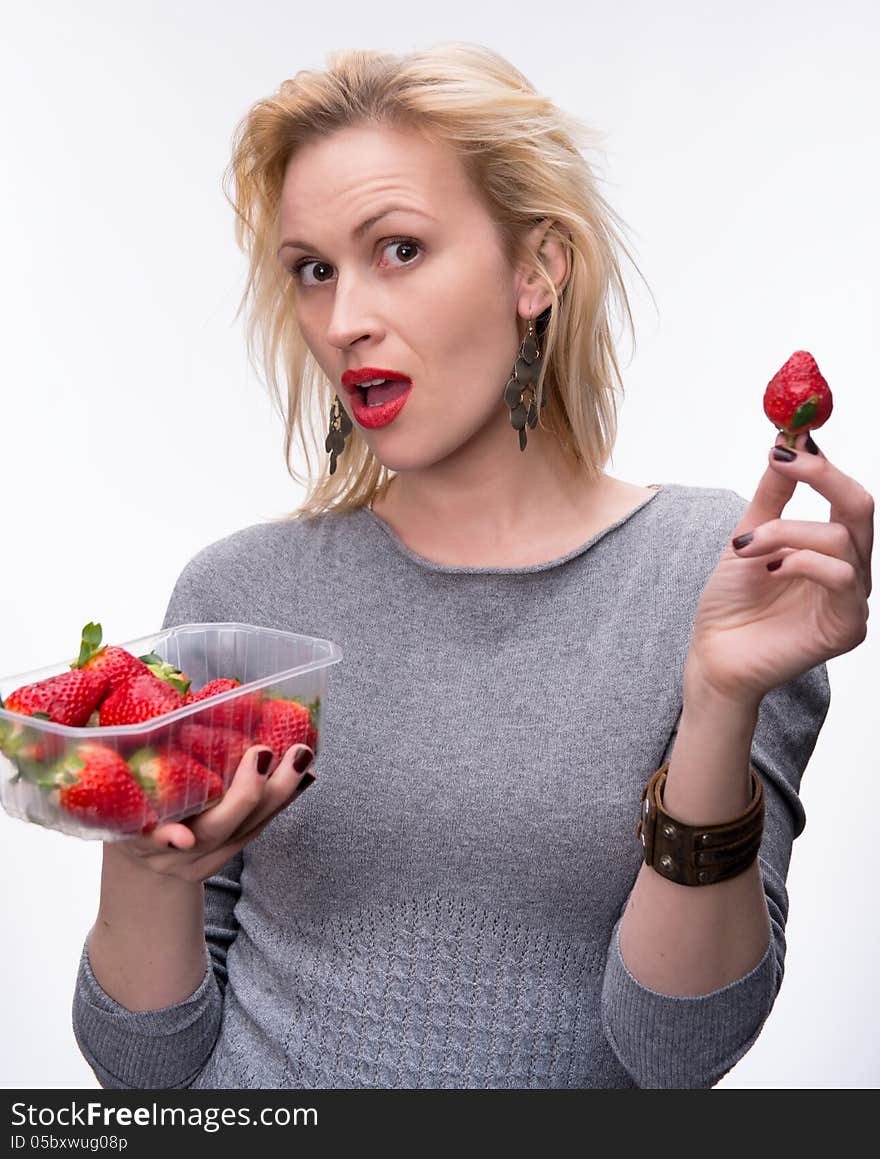 Young happy blond girl with fresh strawberries on a white background