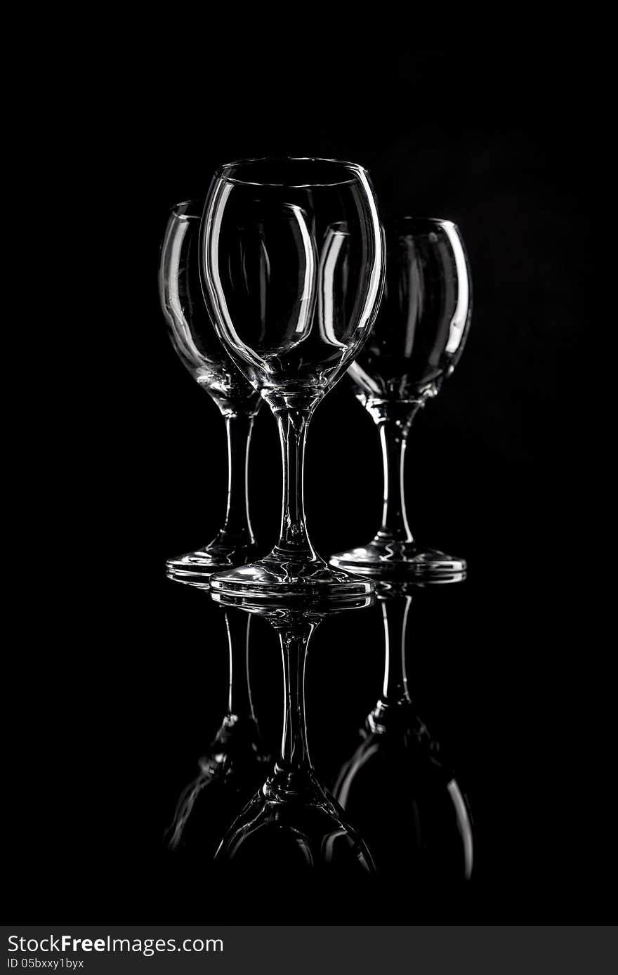 Set of three clean and empty wineglasses and reflection. Selective focus. Shot in studio. Set of three clean and empty wineglasses and reflection. Selective focus. Shot in studio.