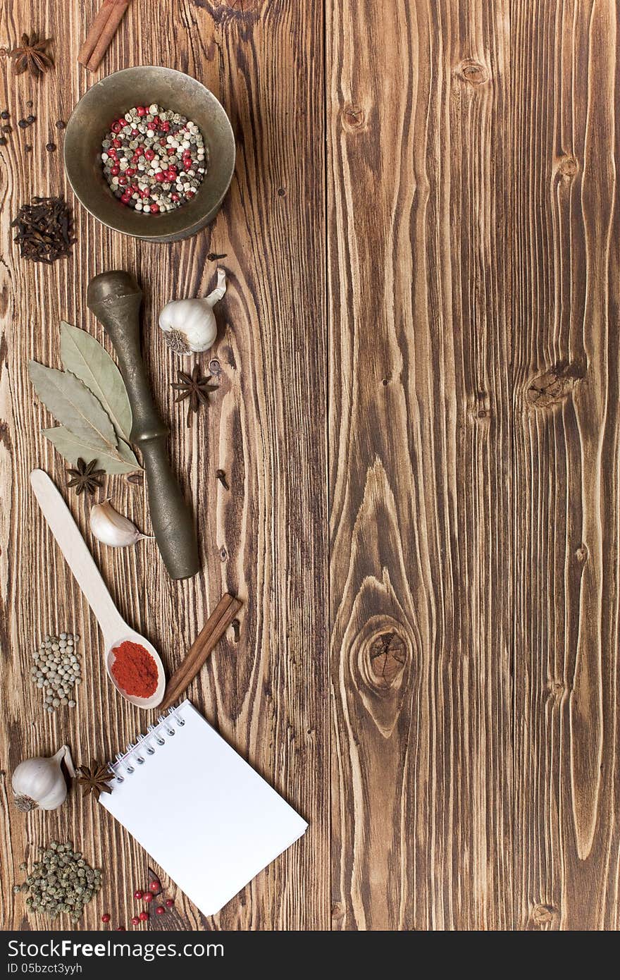 Spices and notepads on a wooden background. Spices and notepads on a wooden background