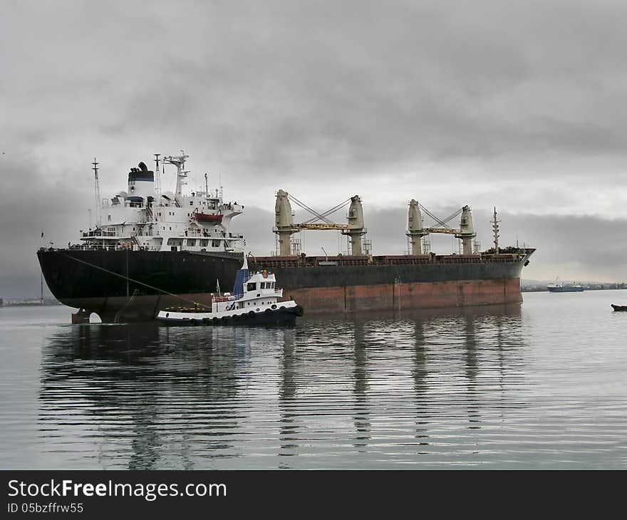 Tug boat towing bulk carrier vessel.