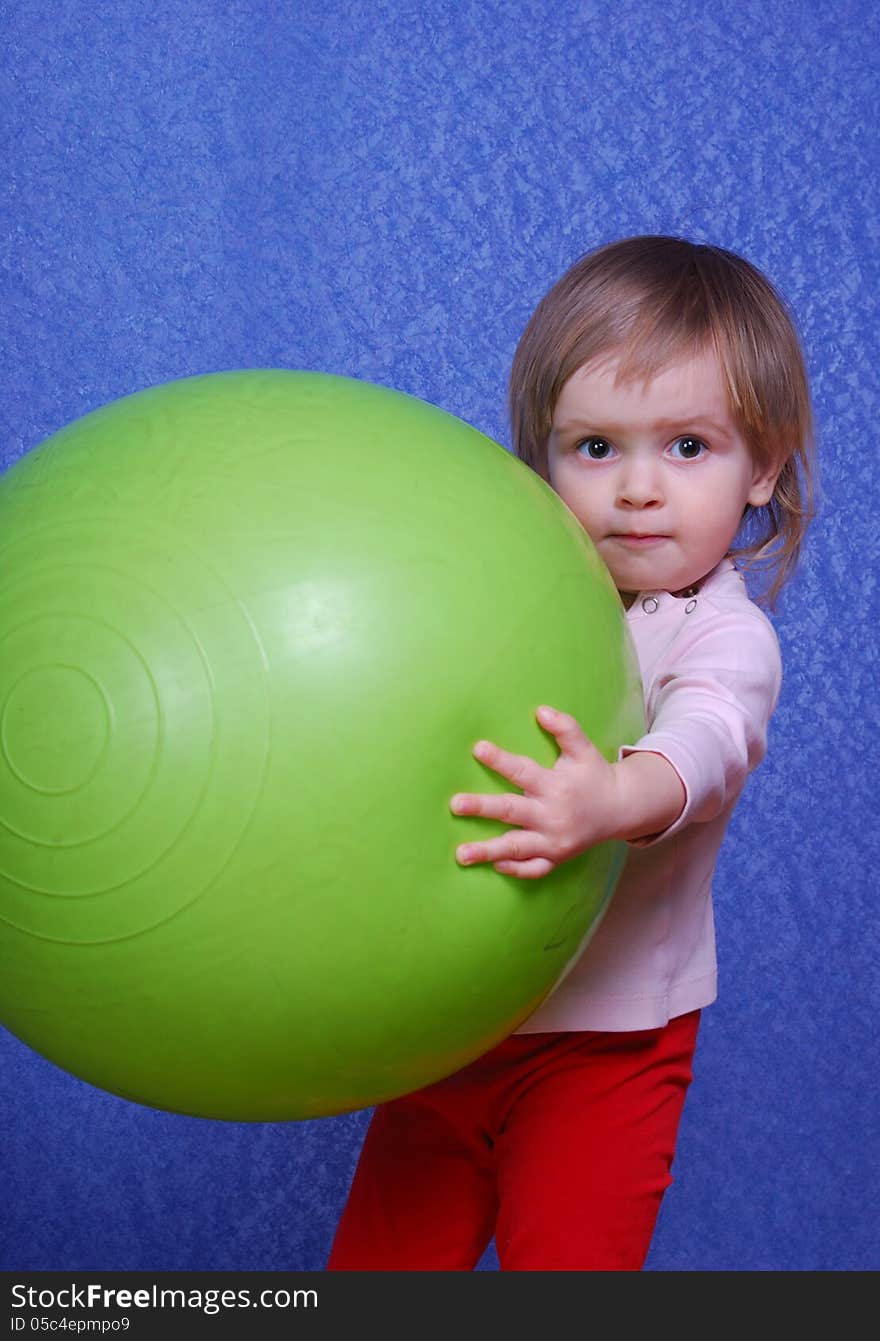 Child with ball, portrait on a blue background