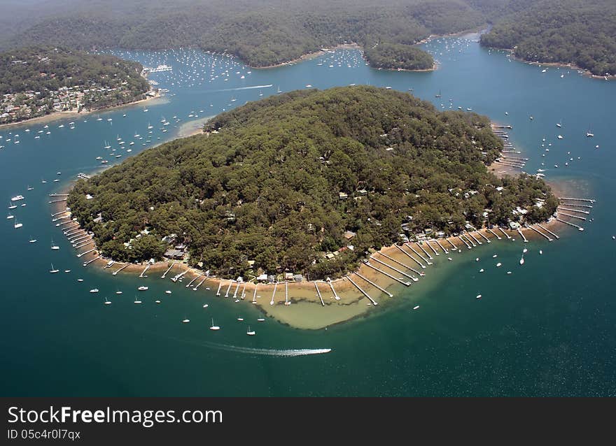 An aerial view of an island near Sydney with many boats moored around it. An aerial view of an island near Sydney with many boats moored around it