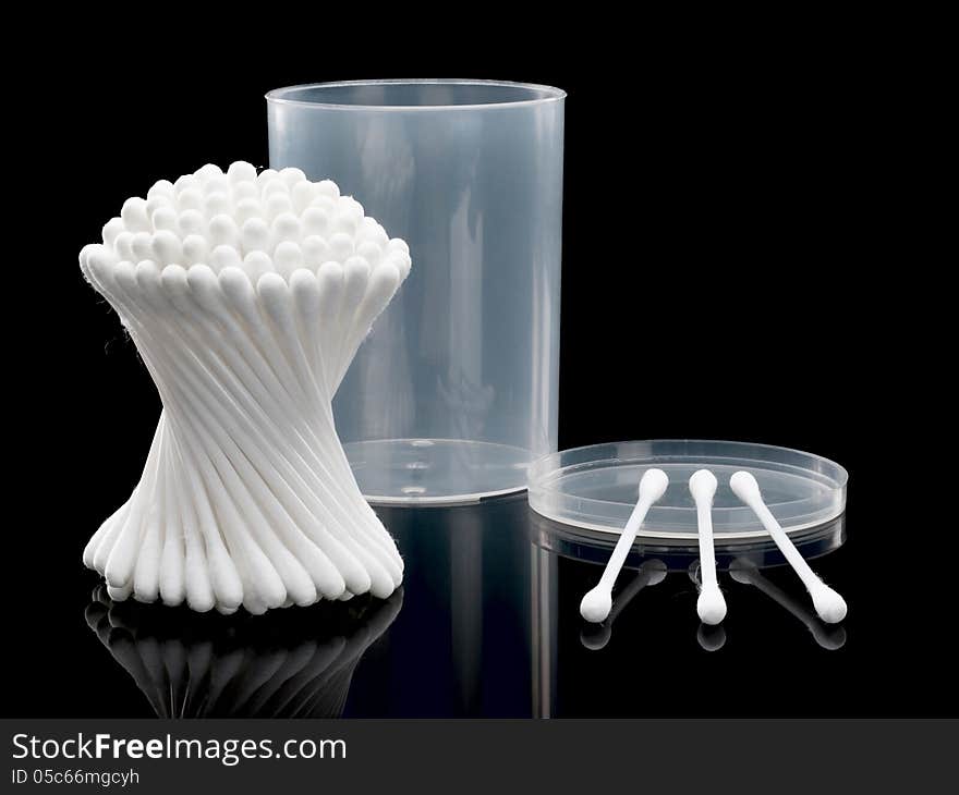 Cotton buds and plastic packing on a black background