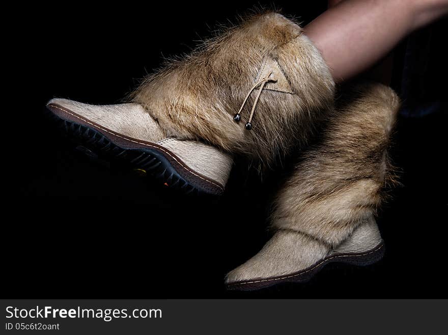 Female winter shoes made of fur. on black background. Female winter shoes made of fur. on black background.