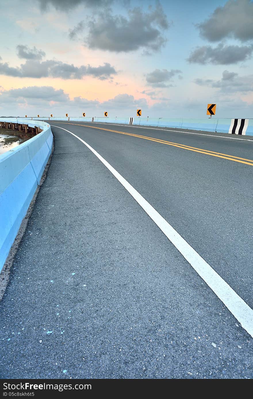 Asphalt road to vertical in cloudy sky