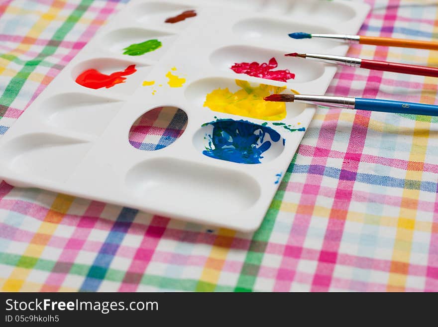 Palette , colors and paintbrushes on colorful background. Palette , colors and paintbrushes on colorful background