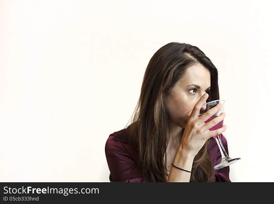 Beautiful young woman with brown hair and eyes holding a pink martini. Beautiful young woman with brown hair and eyes holding a pink martini.