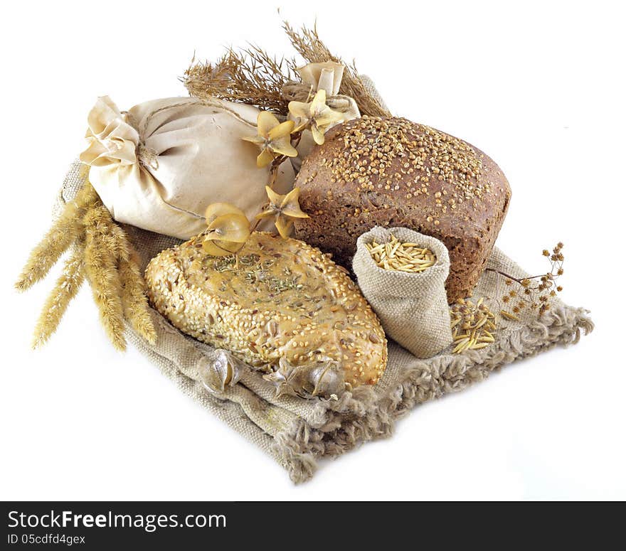 Different types of bread with herbs on hessian fabric isolated. Different types of bread with herbs on hessian fabric isolated