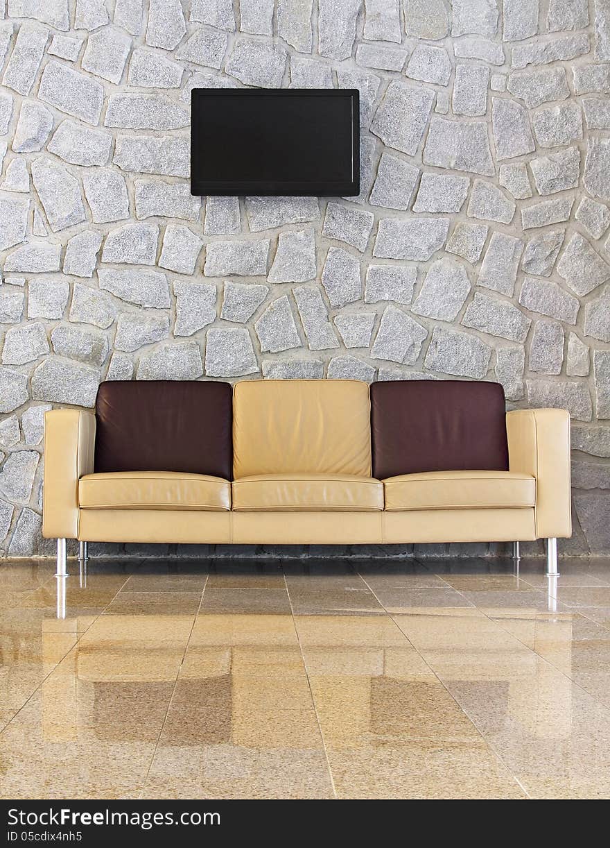 Leather sofa in front of the stone wall