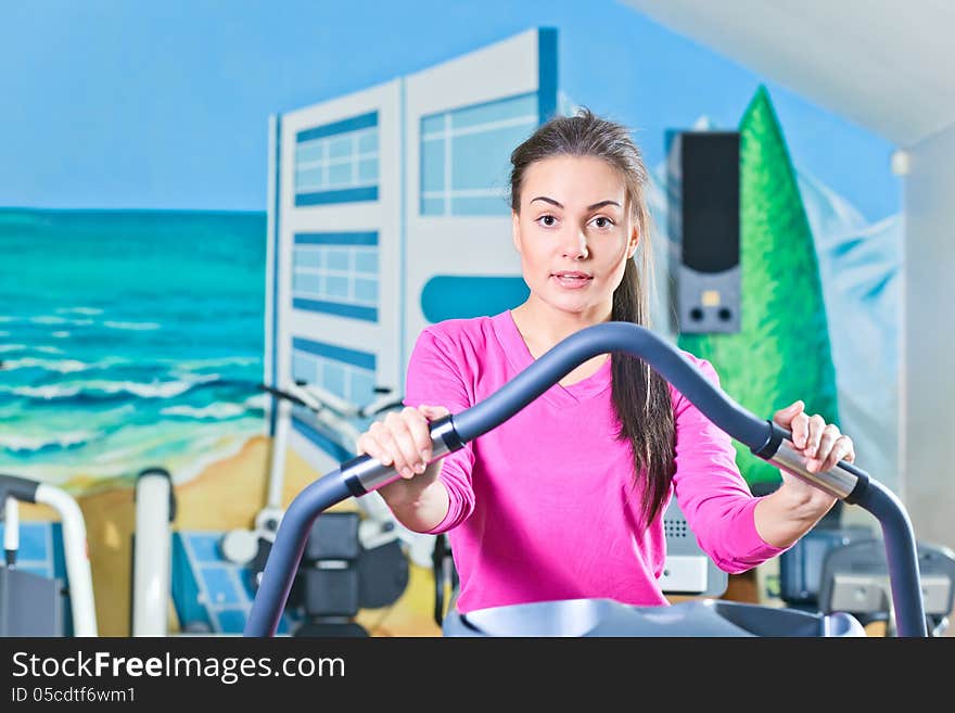 Young beautiful girl working out in a gym. Young beautiful girl working out in a gym