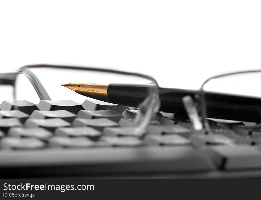 Points lie on the keyboard next to the fountain pen on a white