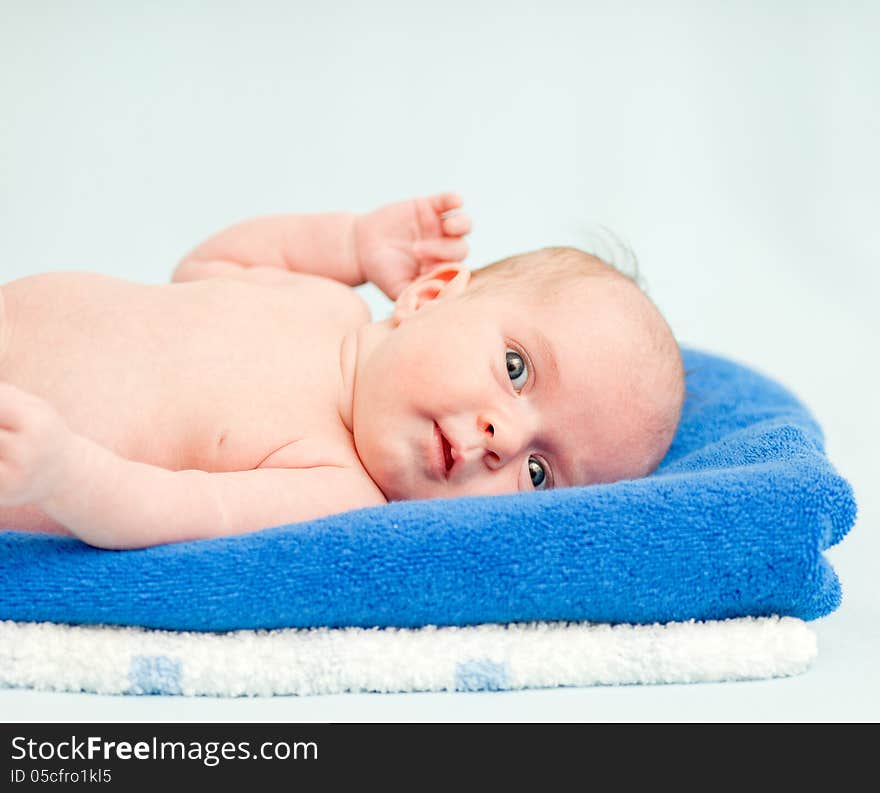 Cute newborn baby lying on a stack of towels