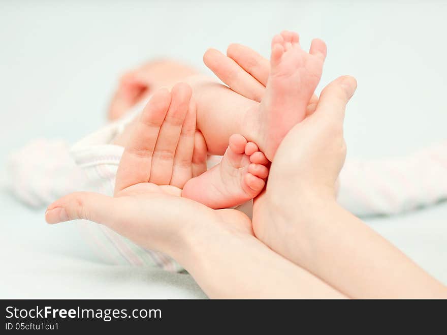 Little baby feet and hands of the mother