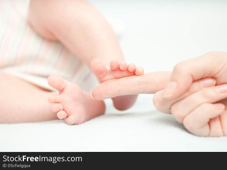 Little baby feet and hand of the mother. This image has attached release.