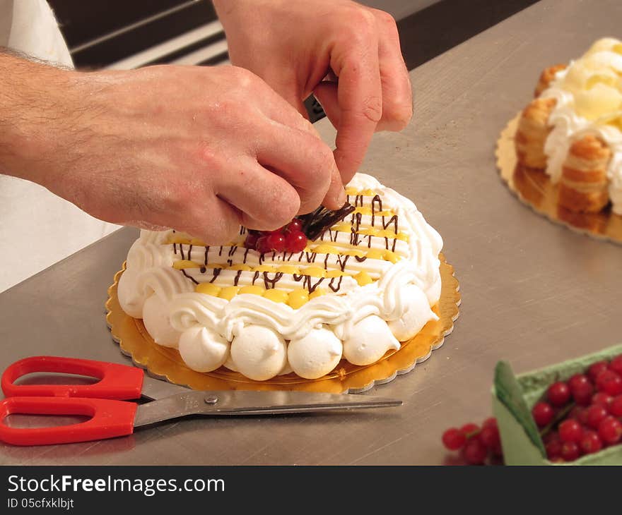 Chef hands preparing cream and chocolate cake. Chef hands preparing cream and chocolate cake.