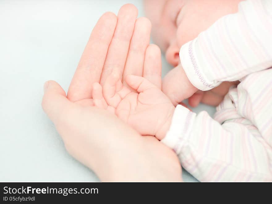 Little baby hands and hand of the mother. This image has attached release.