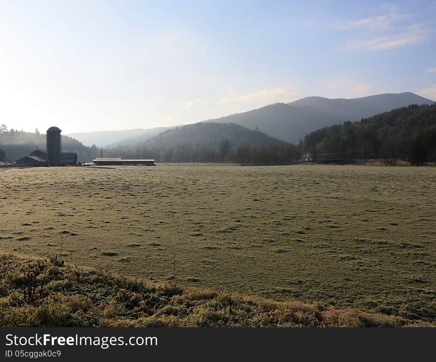 Early morning farmland with fog lifting at sunrise and mountain horizon. Early morning farmland with fog lifting at sunrise and mountain horizon.