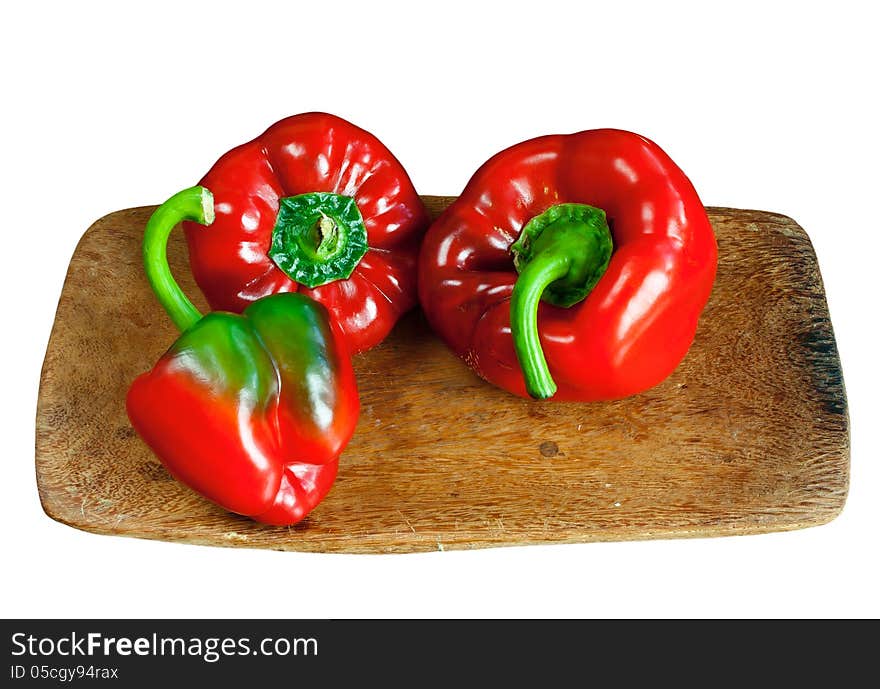 Red ripe sweet pepper on wooden board isolated over white. Red ripe sweet pepper on wooden board isolated over white