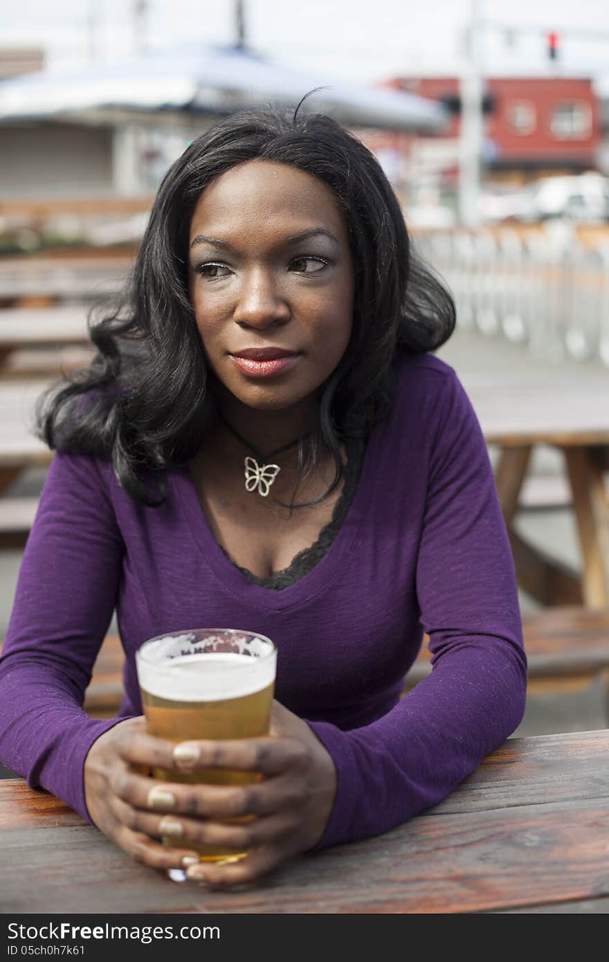 Young African American woman and a pint of pale ale. Young African American woman and a pint of pale ale.