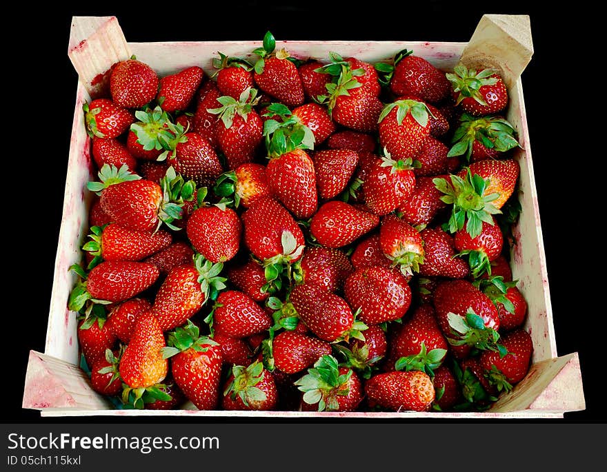 Strawberry in wooden box over black background. Strawberry in wooden box over black background