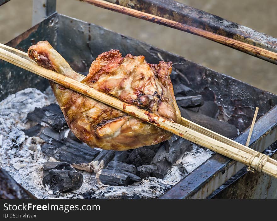 Close up of a chicken skewer in a barbecue at a food street market in Laos. Close up of a chicken skewer in a barbecue at a food street market in Laos.