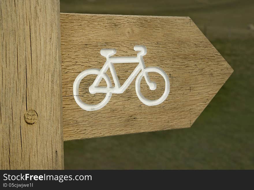 Wooden post showing cycle route in countryside. Wooden post showing cycle route in countryside