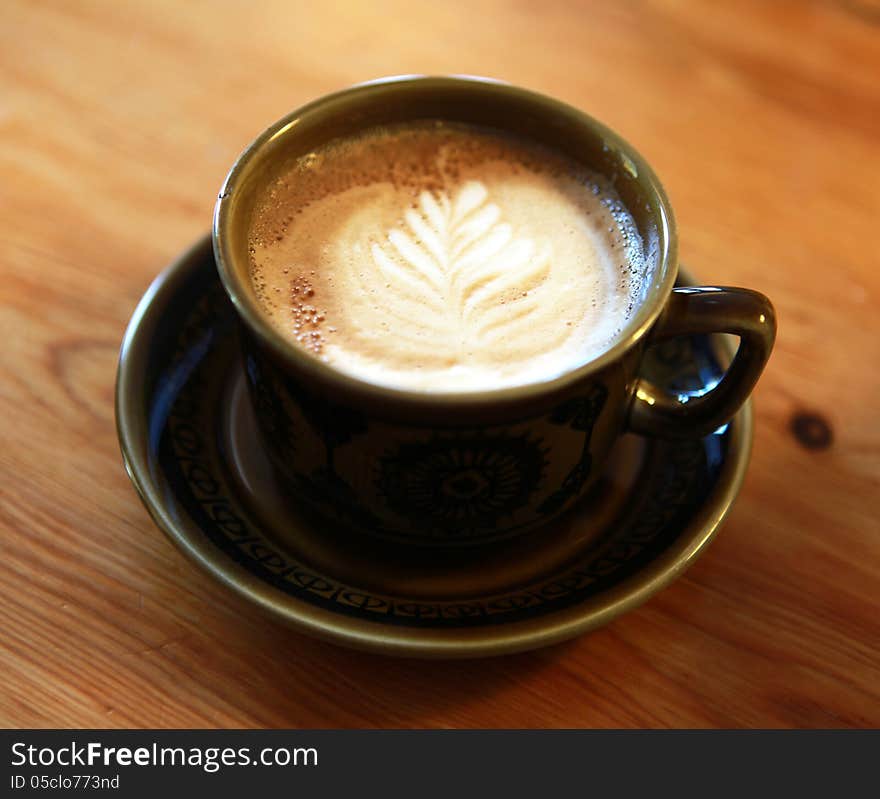 One single cup of coffee with a nice pattern in the cappuchino milk