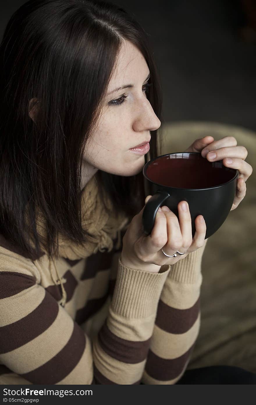 Young Woman with Brown Hair and Eyes Holding Black Cofee Cup