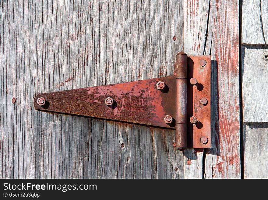 Rusty hinge on a wooden barn door. Rusty hinge on a wooden barn door