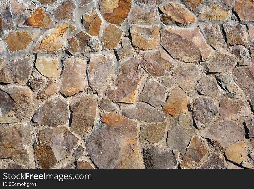 Irregular texture of the old yellow stone wall outside