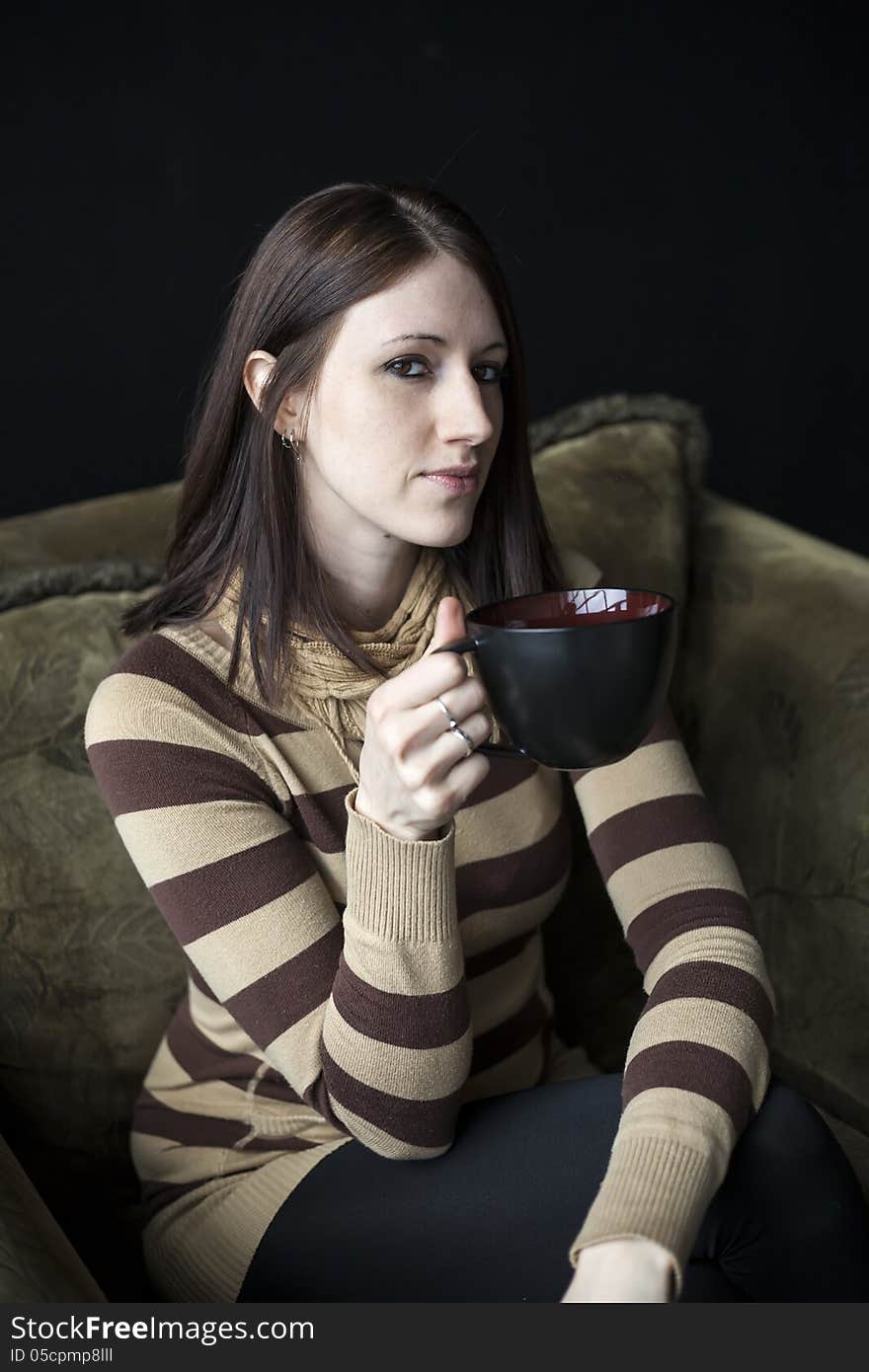 Beautiful young woman with brown hair and eyes holding a black coffee cup. Beautiful young woman with brown hair and eyes holding a black coffee cup.