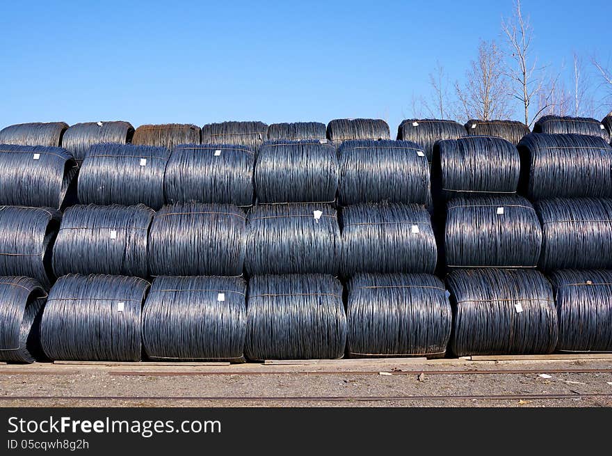 Stacked rows of newly manufactured steel wire coils. Stacked rows of newly manufactured steel wire coils.