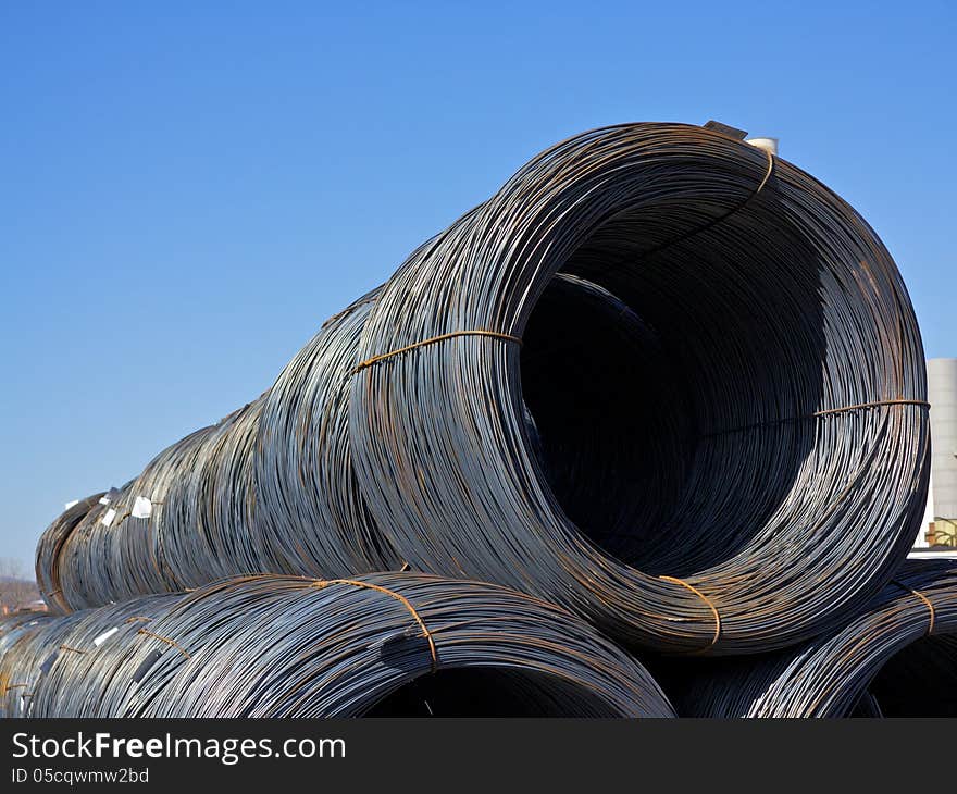 Top of a Stacked row of newly manufactured steel wire coils. Top of a Stacked row of newly manufactured steel wire coils.