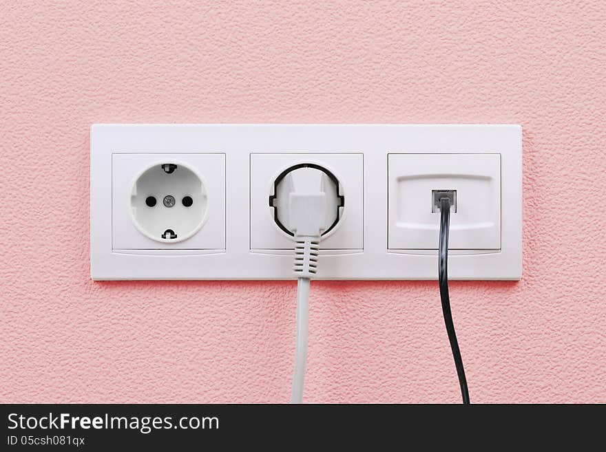 Electric and internet outlets on pink wall, electric cable and internet. Electric and internet outlets on pink wall, electric cable and internet