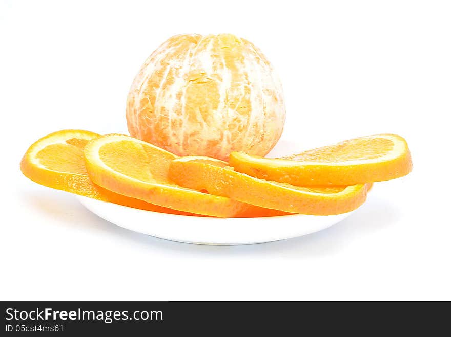 Orange and orange pieces on a plate and white background. Orange and orange pieces on a plate and white background