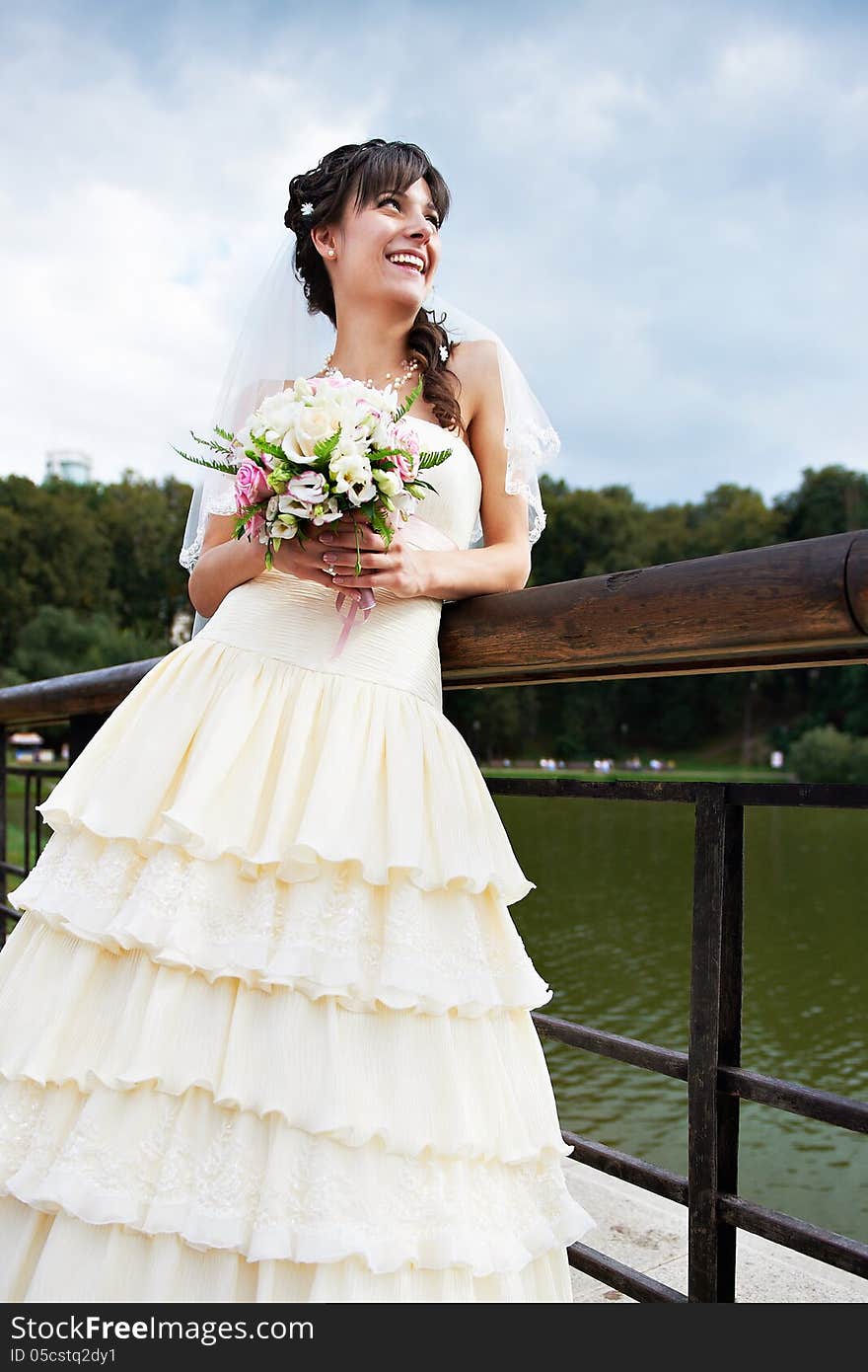 Happy bride about lake in summer day