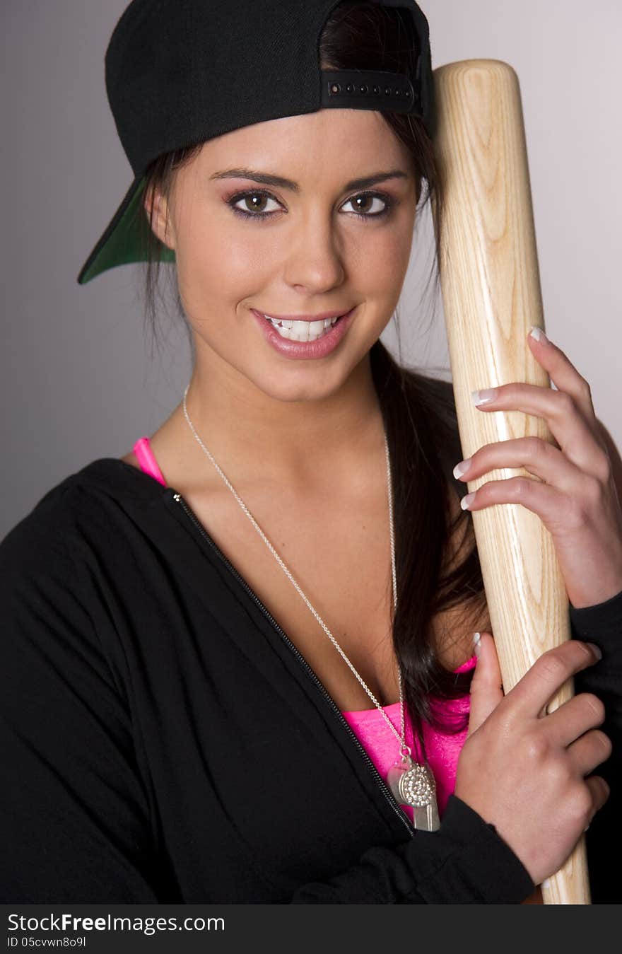 Pretty Female Baseball Lover Holds A Wooden Bat And Smiles