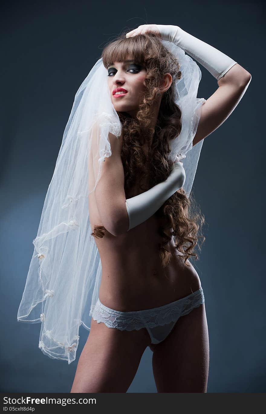 Portrait of girl in veil and panties showing shapely beautiful body in the studio. Portrait of girl in veil and panties showing shapely beautiful body in the studio