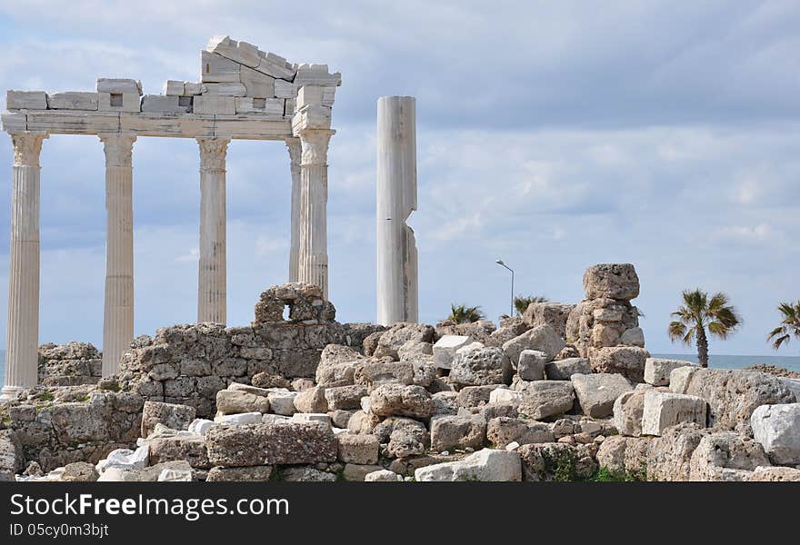 Image shows the Apollo-Temple of Side, Turkey. In the front some small stones, some ruins in the middle. Sky is cloudy. Image shows the Apollo-Temple of Side, Turkey. In the front some small stones, some ruins in the middle. Sky is cloudy.