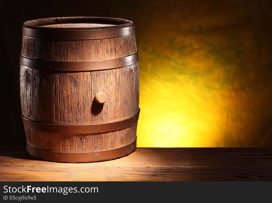 Wooden barrel on a dark yellow background. Wooden barrel on a dark yellow background.