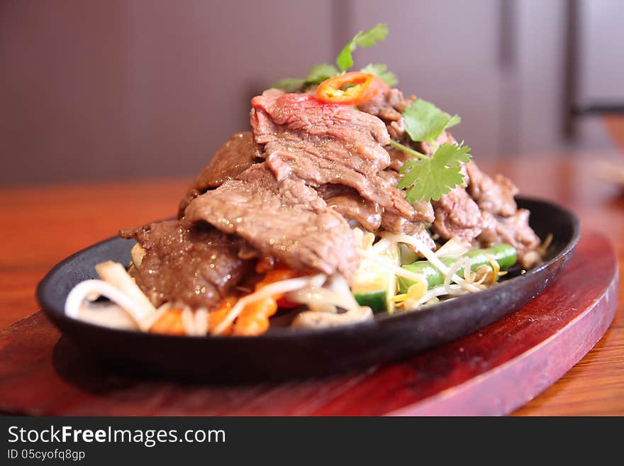 Hot plate with beef sizzling and fresh vegetables. Hot plate with beef sizzling and fresh vegetables.