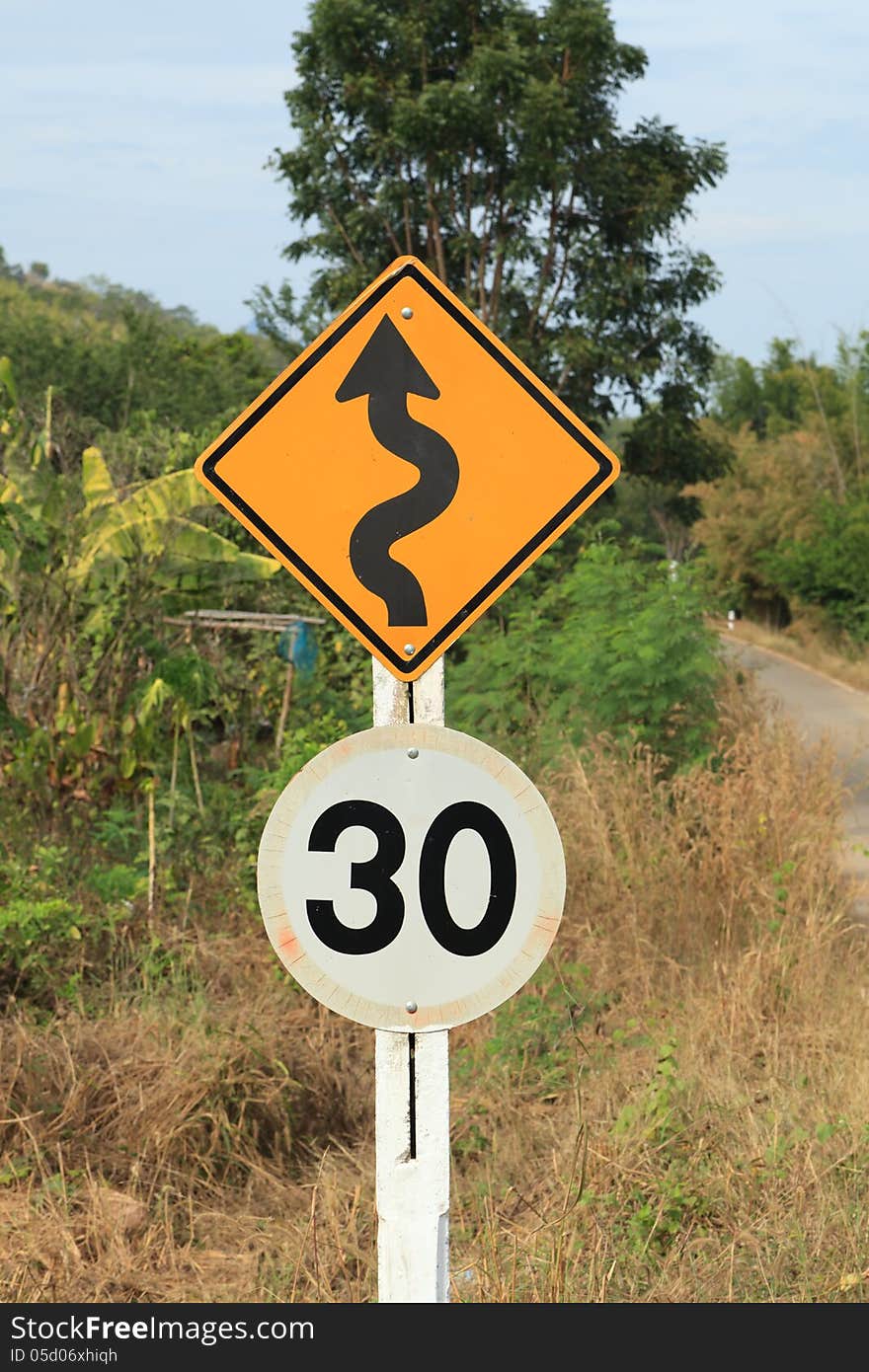 Zig Zag road warning sign and 30km limit speed limit sign in country side