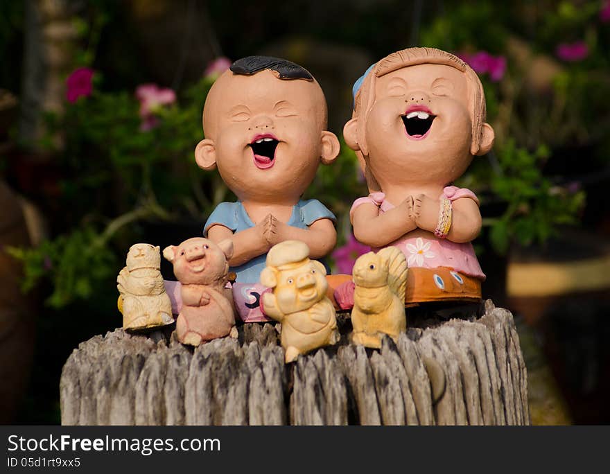 Clay doll boy and girl in garden