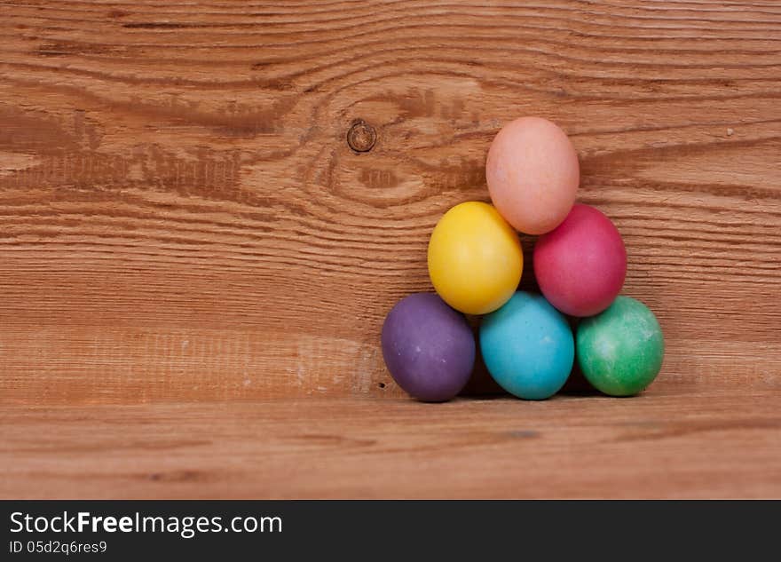 Pyramid on a wooden background of colored eggs for Easter. Pyramid on a wooden background of colored eggs for Easter